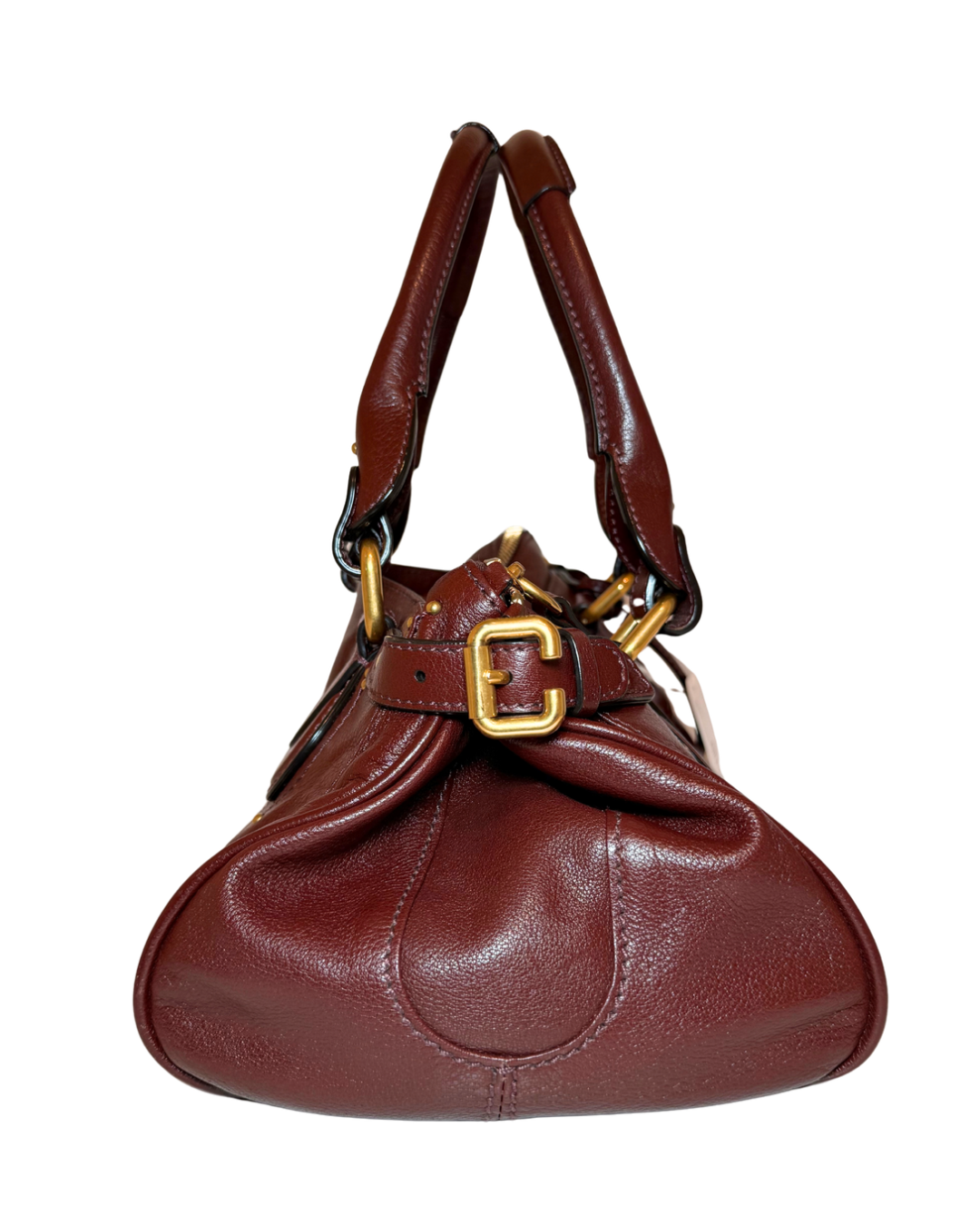 A dark reddish-brown leather handbag with a gold buckle detail and gold-toned hardware, shown against a plain white background.